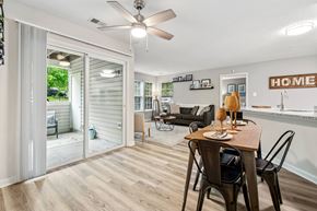 Ellicott City apartment for rent - A dining room with a table set for two and a sliding glass door leading to a backyard.
