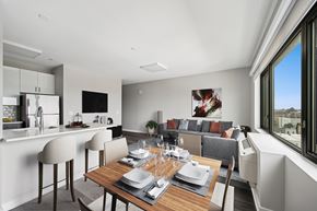 West New York apartment for rent - A modern dining room with a wooden table set for a meal.