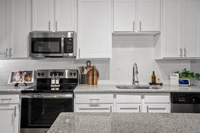Charlotte apartment for rent - A modern kitchen with white cabinets and a granite countertop.