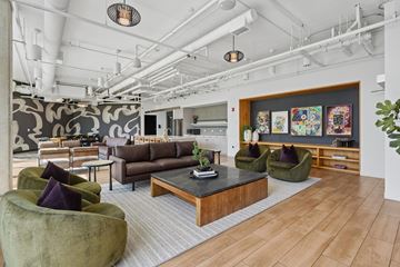 Chicago apartment for rent - A modern living room with a dark wood coffee table and green velvet chairs.