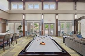 Woodbridge apartment for rent - A pool table is in the middle of a room with a couch and chairs.