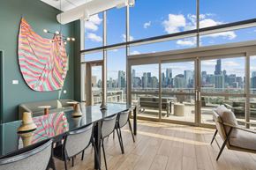 Chicago apartment for rent - A room with a table and chairs with a view of the city.