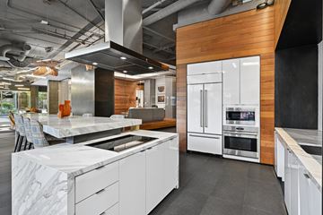 Alexandria apartment for rent - A modern kitchen with white cabinets and a wooden accent wall.