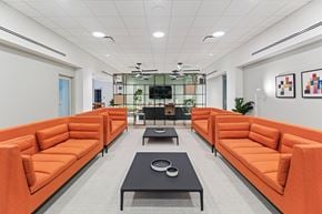 Philadelphia apartment for rent - A modern office space with orange couches and a black coffee table.