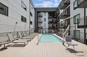 Richmond apartment for rent - A pool surrounded by sun loungers on a wooden deck.