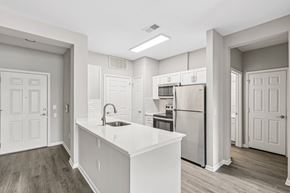 Portsmouth apartment for rent - a white kitchen with a large island and stainless steel refrigerator