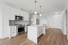 Alexandria apartment for rent - A kitchen with white cabinets and a wooden floor.