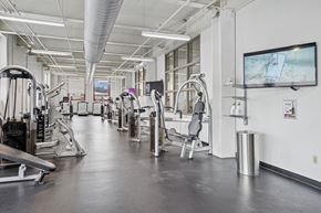Pittsburgh apartment for rent - A gym with a variety of equipment including treadmills, weights, and a television.