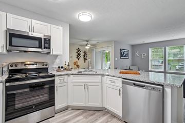 Ellicott City apartment for rent - A kitchen with white cabinets and a black stove top oven.
