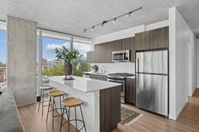 Chicago apartment for rent - A kitchen with a white counter and stools.