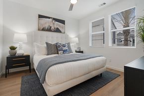Chula Vista apartment for rent - A bedroom with a large bed, a painting of a horse, and a ceiling fan.