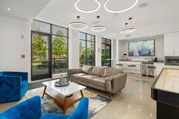 Beverly apartment for rent - A modern living room with a blue chair and a brown couch.