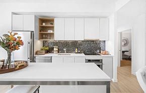 Boston apartment for rent - a kitchen with white cabinets and a white table