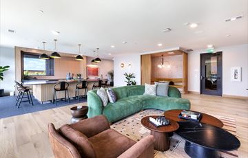 Austin apartment for rent - A modern living room with a green couch and brown chairs.