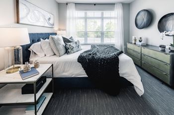 A black and white bedroom with a bed and a window