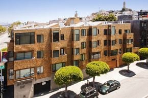 San Francisco apartment for rent - a view from above of a brick apartment building with cars parked in front of it