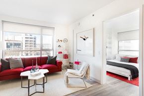 San Francisco apartment for rent - Dog Friendly Apartments in San Francisco CA - Trinity Place at 33 8th - Living Room with White, Red, and Pink Decor, a Large Window, a TV, Wall Art, Furniture, High Ceilings and Carpet