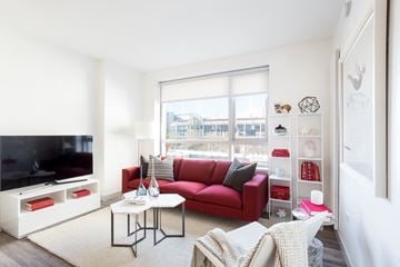 San Francisco apartment for rent - a living room with a red couch and a large window