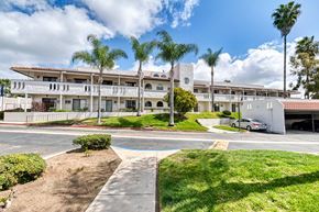 Vista apartment for rent - A building with a white fence and a car parked in front.