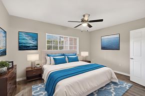 Miramar apartment for rent - A bedroom with a bed, two nightstands, a ceiling fan, and two pictures on the wall.