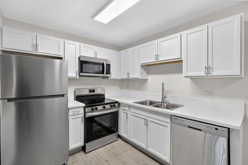 Tampa apartment for rent - A kitchen with white cabinets and stainless steel appliances.