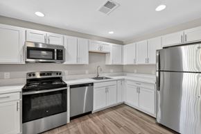 Lehigh Acres triplex for rent - A kitchen with white cabinets and stainless steel appliances.