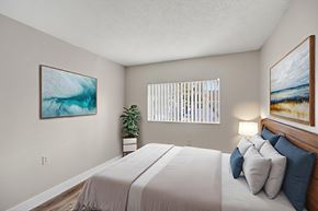 West Palm Beach apartment for rent - A bedroom with a large bed and two framed pictures on the wall.