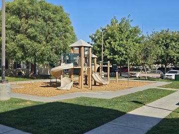 Mendota apartment for rent - A playground with a wooden structure and a slide.