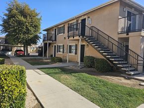 Mendota apartment for rent - A building with a black railing staircase.