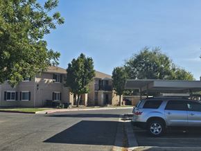 Mendota apartment for rent - A silver SUV is parked in a parking lot in front of a building.