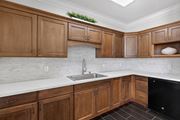Orlando apartment for rent - A kitchen with wooden cabinets and a black dishwasher.