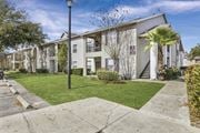 Orlando apartment for rent - A street lamp stands in front of a building with a white facade and a green lawn.