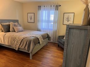 Holly Hill apartment for rent - A bedroom with a bed, a chair, and a cabinet.