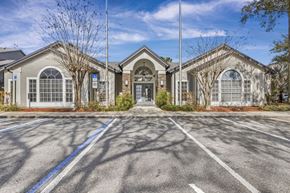 Orlando apartment for rent - A large building with a parking lot in front of it.
