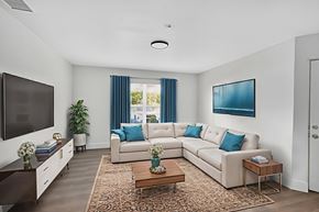 Ft. Myers apartment for rent - A living room with a white couch and a television. at Cascades at Clear Lake Apartments, Ft. Myers, 33908
