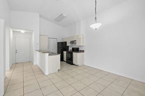 Naples condo for rent - A kitchen area with a white counter and black appliances.