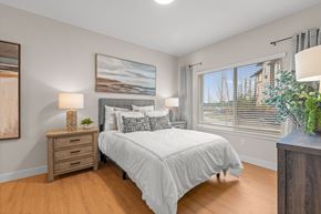Milton townhouse for rent - A bedroom with a bed, nightstand, and a painting on the wall.