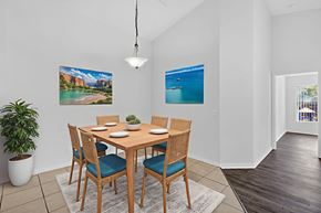 Naples condo for rent - A dining room with a table set for six with a view of a beach.