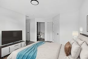 Ft. Myers apartment for rent - A bedroom with a bed, a television, and a mirror. at Cascades at Clear Lake Apartments, Ft. Myers, Florida