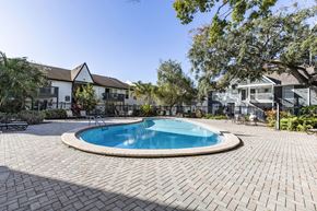 Tampa apartment for rent - A swimming pool surrounded by a brick patio. at Foxcroft Apartments, Apartments, Tampa, FL