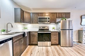 Vista apartment for rent - A modern kitchen with wooden cabinets and stainless steel appliances.