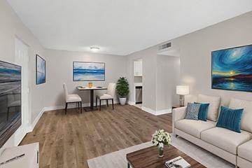 West Palm Beach apartment for rent - A living room with a white couch, a coffee table, and a painting on the wall.