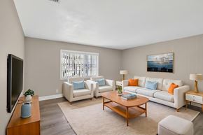 Tampa apartment for rent - A living room with a white couch, a coffee table, and a television. at Willow Brooke Apartments, Apartments, Tampa, FL
