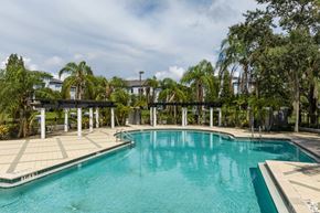 Riverview apartment for rent - A pool surrounded by trees and a white fence.