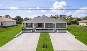 Lehigh Acres triplex for rent - A house with a grey roof and a white fence.