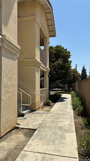 Selma apartment for rent - A concrete staircase with a metal railing leads up to a building.