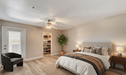 Las Vegas apartment for rent - A bedroom with a bed, chair, and a plant.