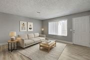 Las Vegas apartment for rent - A living room with a grey couch, a wooden coffee table, and two framed pictures on the wall.