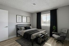 Las Vegas apartment for rent - A bedroom with a bed, chair, and two pictures on the wall.