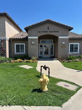 Orange Cove apartment for rent - A yellow fire hydrant is in front of the entrance to Los Arboles Apartments.